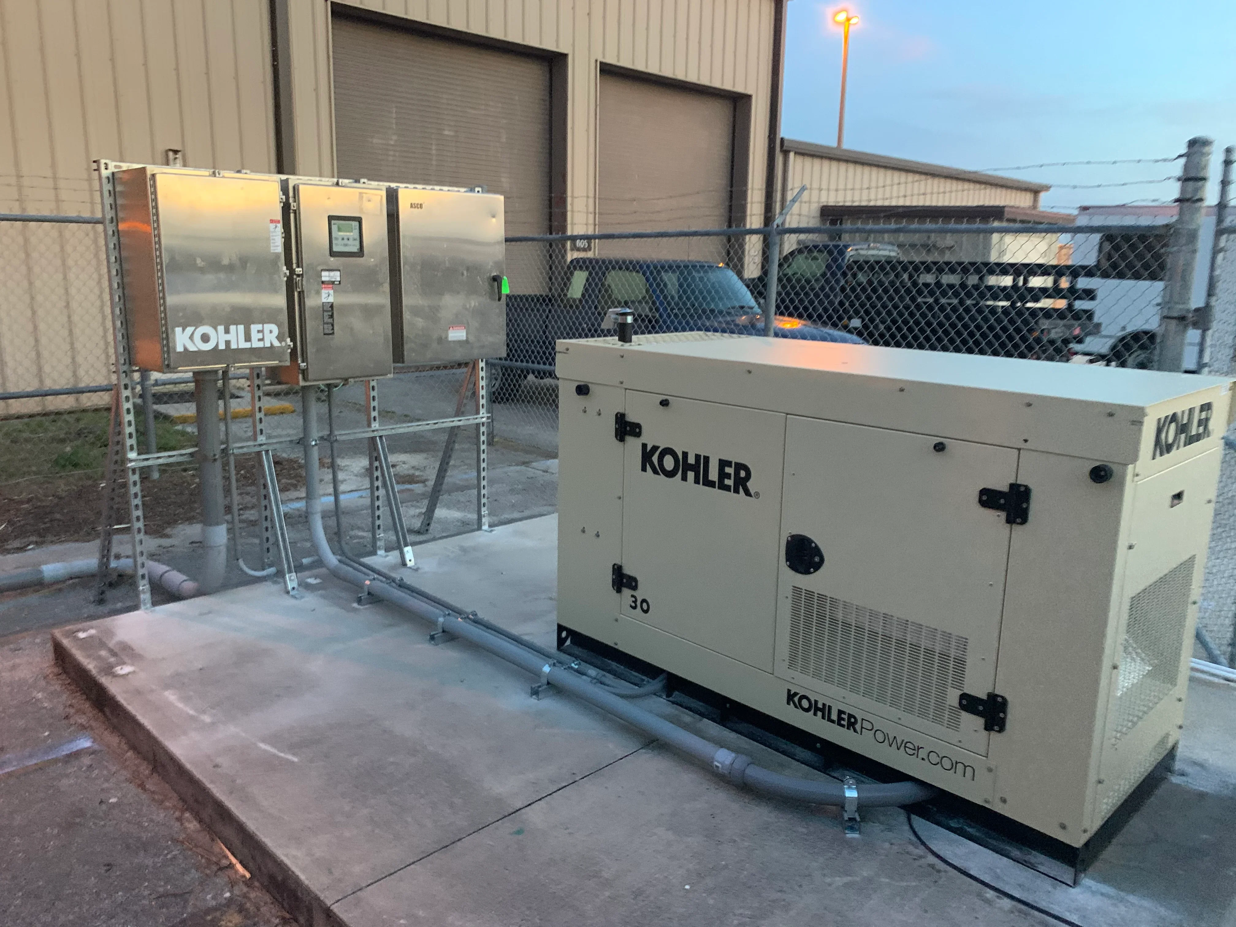 Kohler 30kW diesel generator with fuel tank and control panel on concrete pad installation
