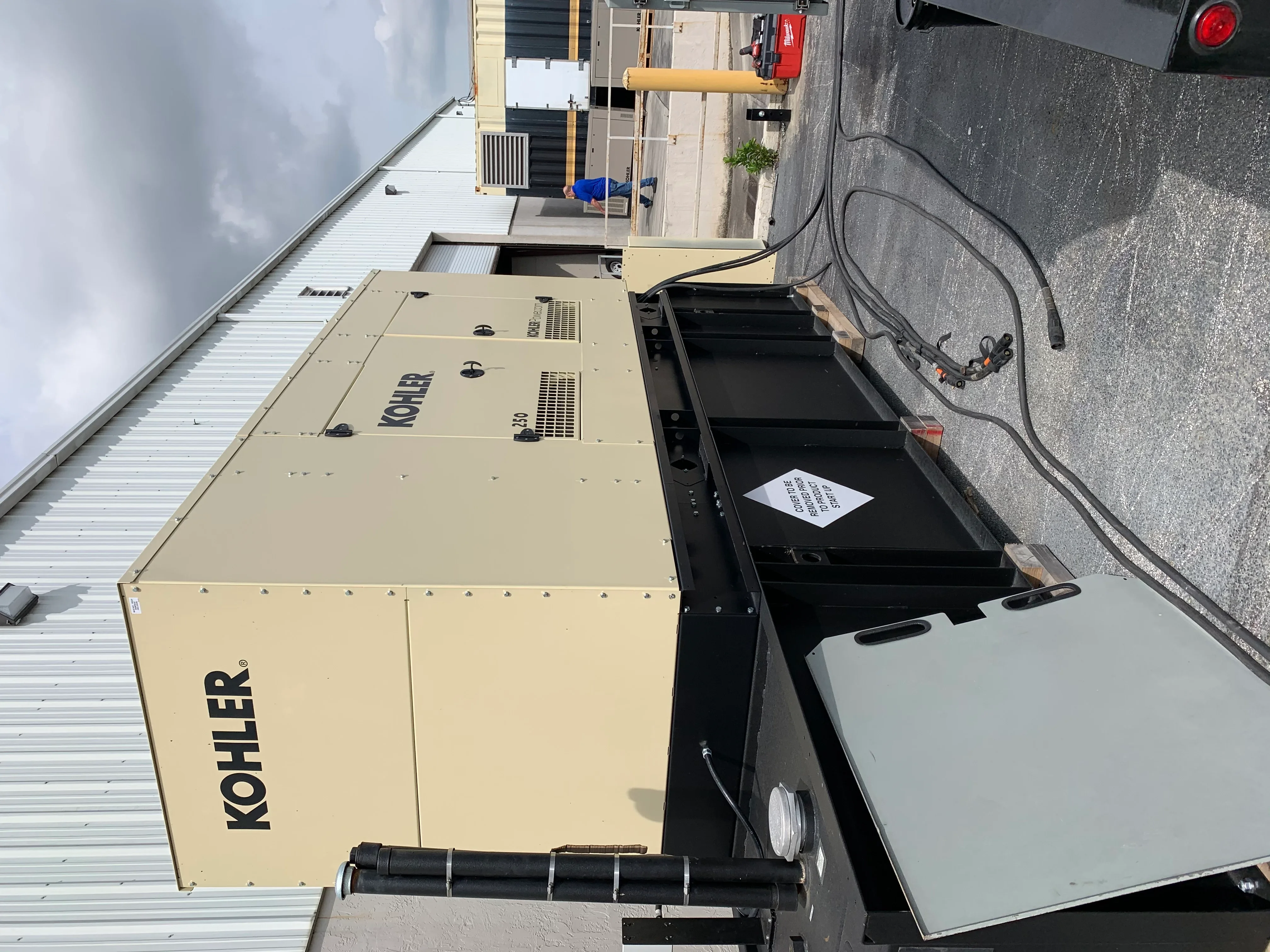 Kohler diesel generator with black fuel tank and electrical connections on rooftop