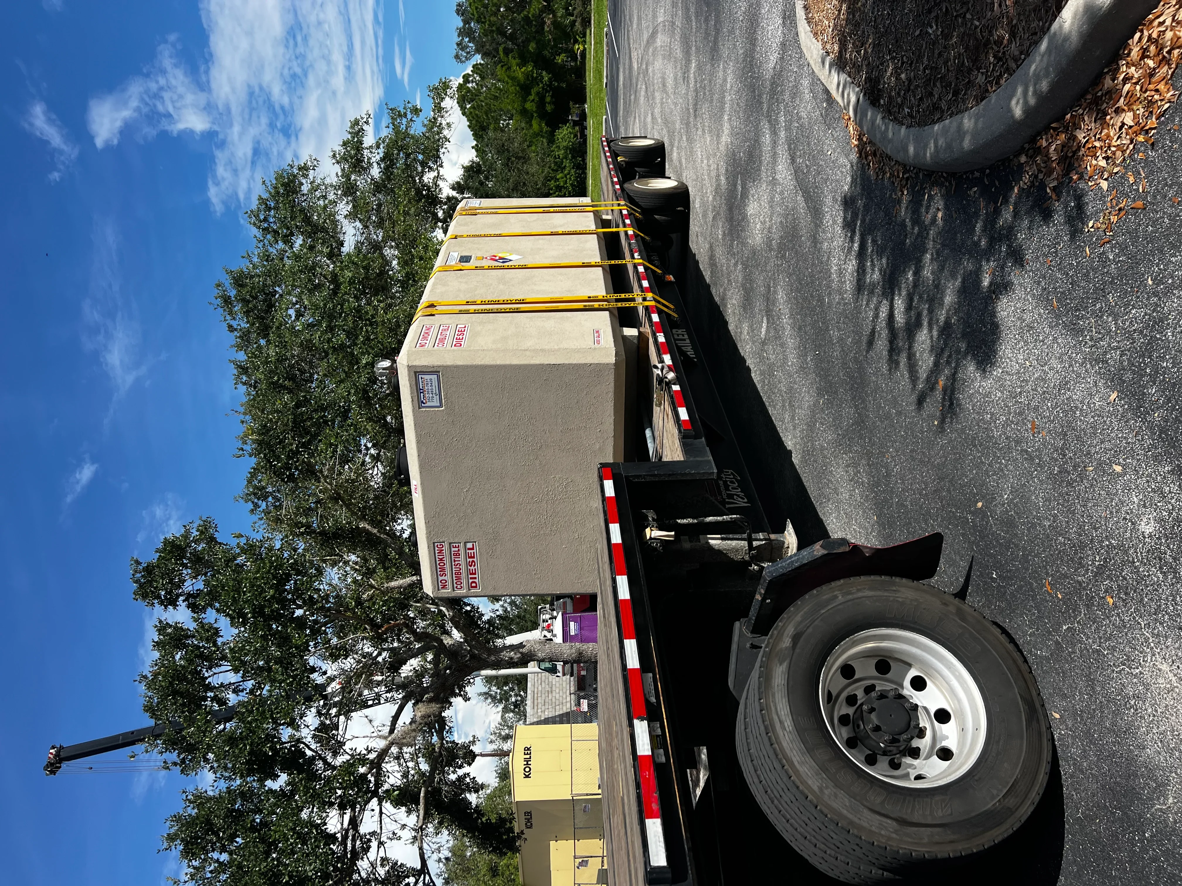 Commercial generator on flatbed trailer with safety striping and securing equipment