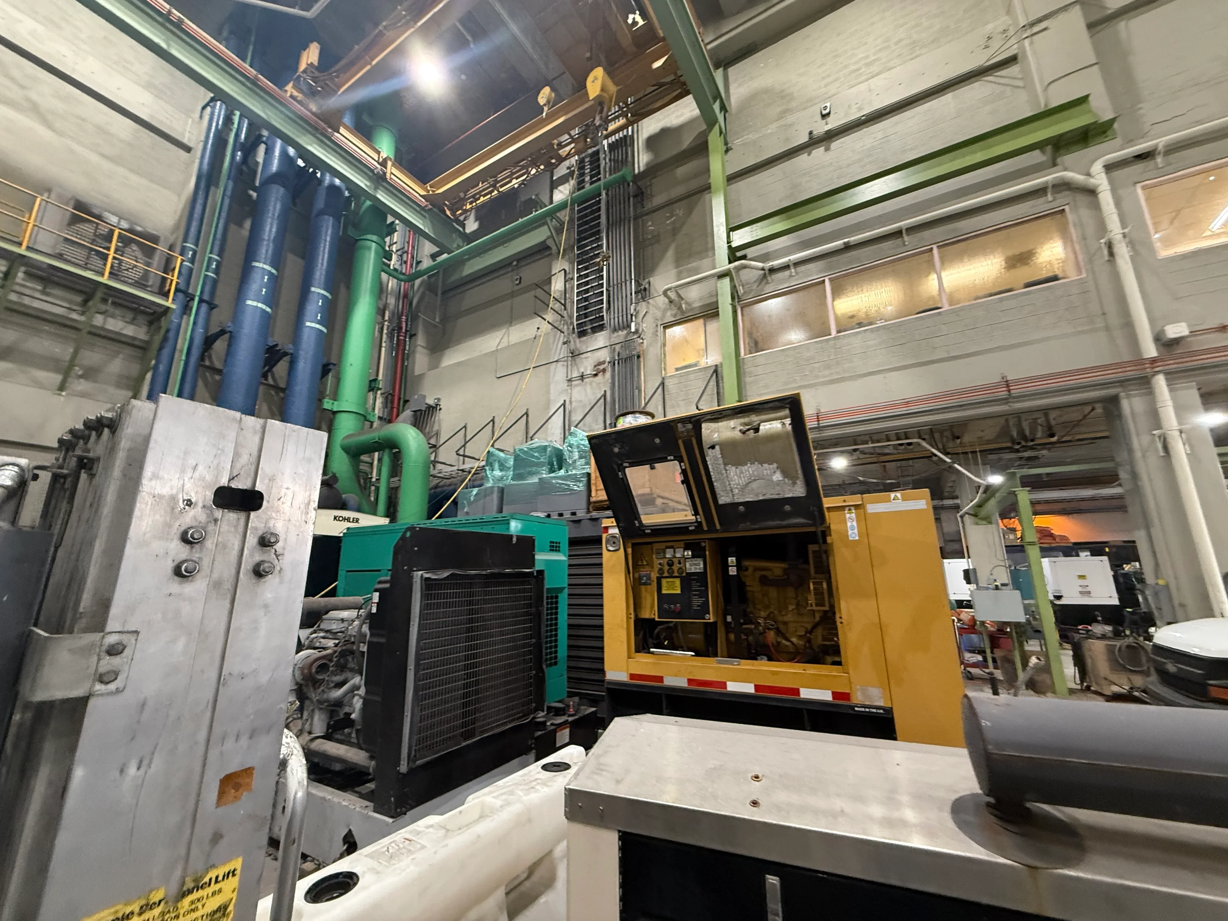 Kohler diesel generator with cooling system, control panel, and piping in industrial facility