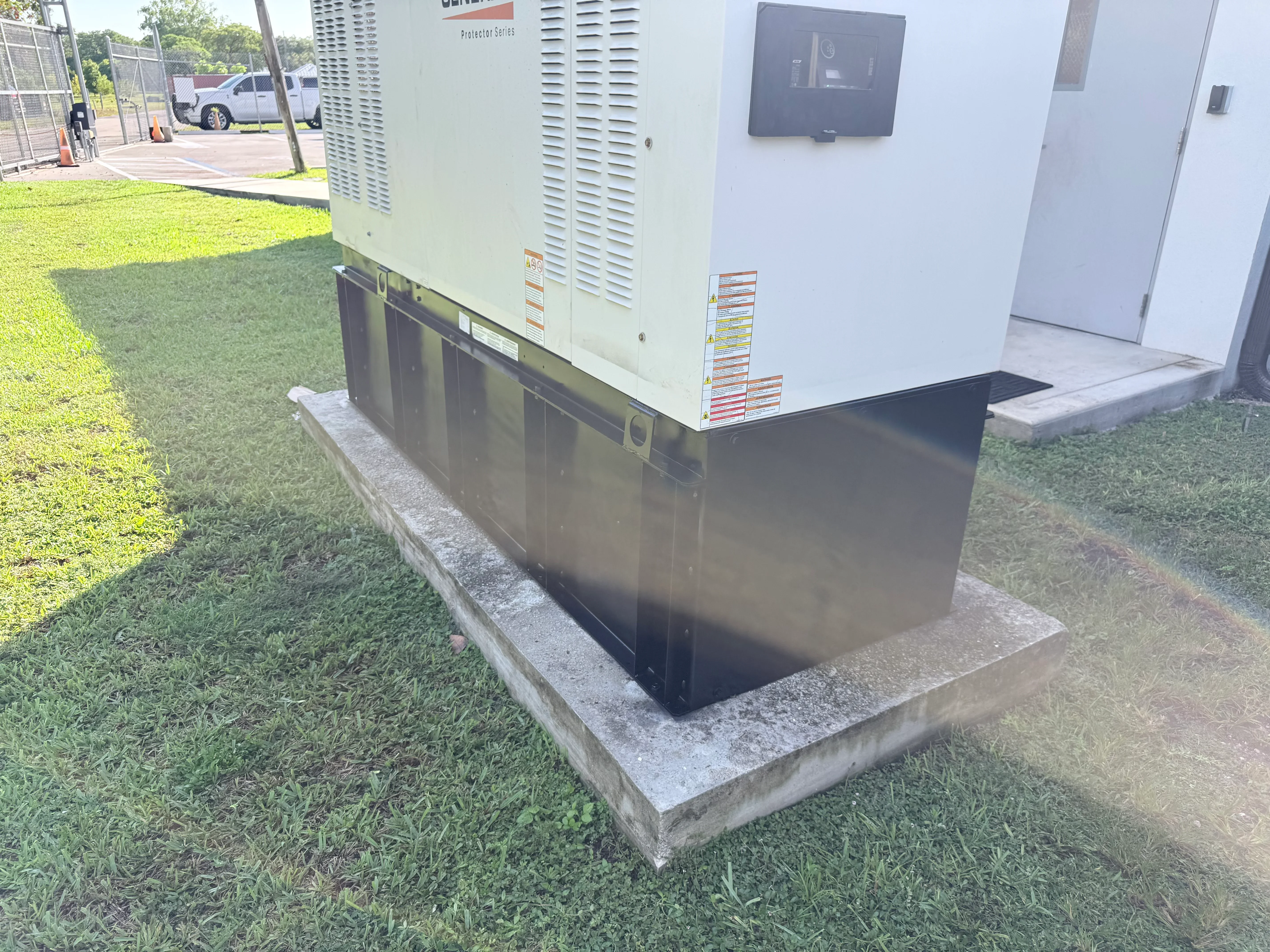 Diesel generator on concrete pad with control panel and ventilation louvers